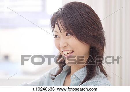 Stock Image - A young woman smiling, close-up. Fotosearch