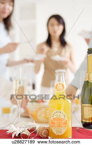 Bottle of orange juice with young women in the background View Large Photo Image Stock Photo - Bottle of orange juice with young women in the background. Fotosearch