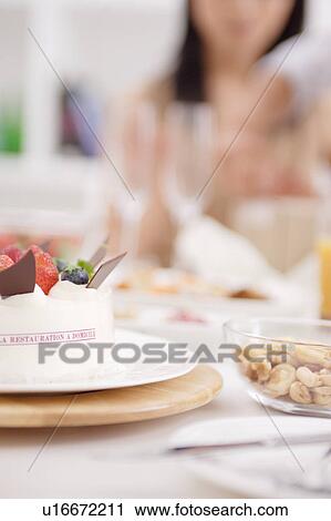 Stock Image - Cake with a woman in the background. Fotosearch