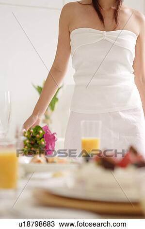 Midsection of a young woman in living room View Large Photo Image Stock Image - Midsection of a young woman in living room. Fotosearch