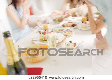 Stock Image - Small group of people having home party. Fotosearch