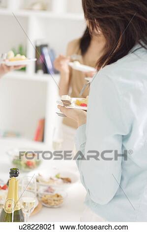 Small group of young women eating at home party View Large Photo Image Stock Image - Small group of young women eating at home party. Fotosearch