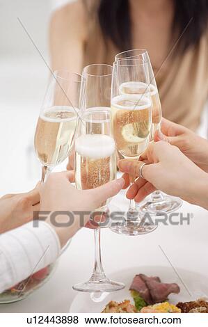 Small group of young women toasting with glasses of champagne View Large Photo Image Stock Photo - Small group of young women toasting with glasses of champagne. Fotosearch