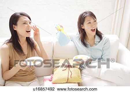 Stock Image - Two young women enjoying party at home. Fotosearch