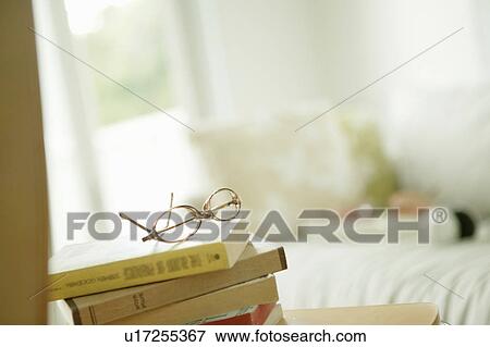Stock Photo - Glasses on top of pile of books. Fotosearch