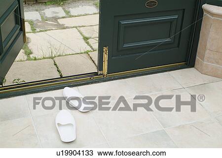 Stock Image - Slippers at entrance. Fotosearch