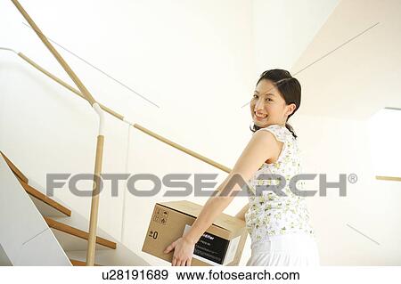 Young woman carrying box View Large Photo Image Stock Photo - Young woman carrying box. Fotosearch