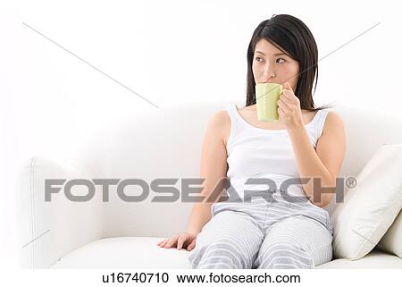 Stock Image - Young woman drinking coffee. Fotosearch