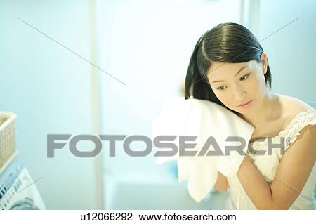 Stock Image - Young woman drying hair with towel. Fotosearch