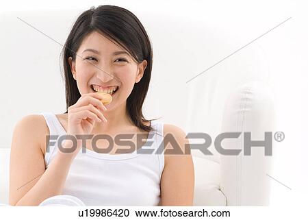 Young woman eating cookie View Large Photo Image Stock Image - Young woman eating cookie. Fotosearch