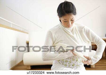 Picture - Young woman getting dressed. Fotosearch