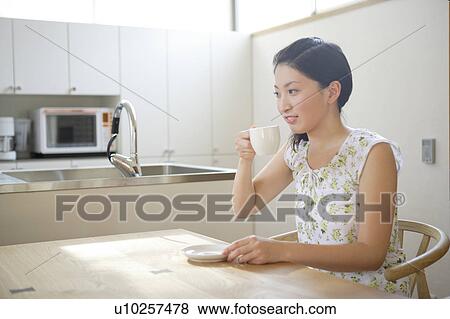 Stock Photo - Young woman having coffee. Fotosearch
