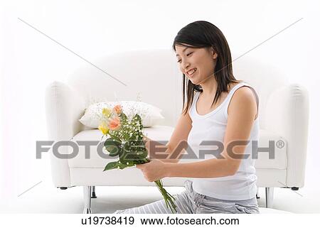Stock Photo - Young woman holding flowers. Fotosearch