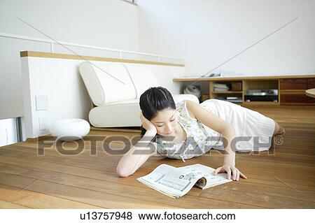 Young woman lying on floor and reading magazine View Large Photo Image Stock Photo - Young woman lying on floor and reading magazine. Fotosearch
