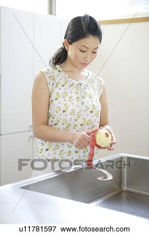 Stock Photo - Young woman peeling apple. Fotosearch