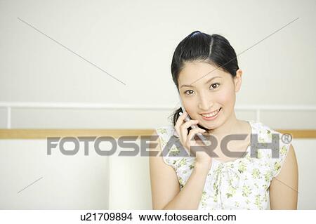 Young woman talking on mobile phone View Large Photo Image Picture - Young woman talking on mobile phone. Fotosearch