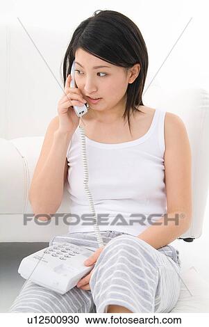 Stock Image - Young woman talking on phone. Fotosearch