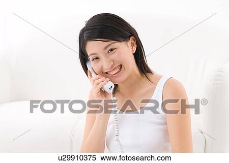 Stock Photography - Young woman talking on phone. Fotosearch