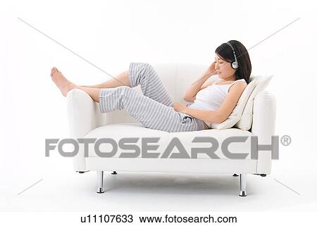 Stock Image - Young woman wearing headphones. Fotosearch