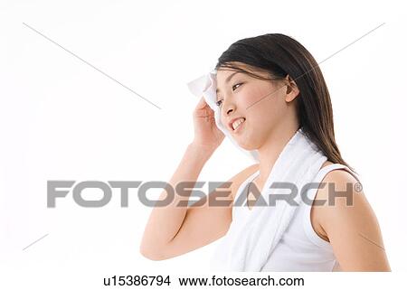 Picture - Young woman wiping her face with towel. Fotosearch