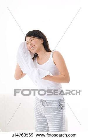 Stock Photo - Young woman wiping her face with towel. Fotosearch