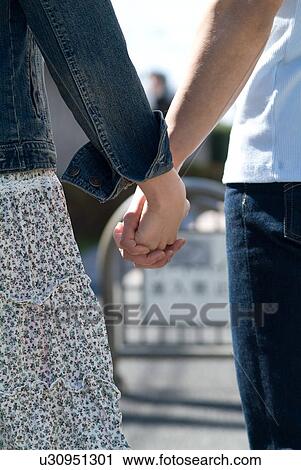 Stock Image - Young couple holding hands. Fotosearch