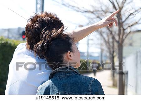 Stock Photography - Young couple looking up, rear view. Fotosearch