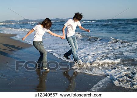 Young couple playing in a beach View Large Photo Image Stock Photo - Young couple playing in a beach. Fotosearch