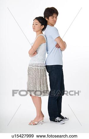 Stock Photo - Young couple standing back to back. Fotosearch