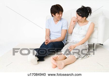 Young couple talking in a living room View Large Photo Image Stock Image - Young couple talking in a living room. Fotosearch
