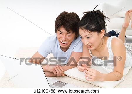 Young couple using laptop computer View Large Photo Image Stock Photo - Young couple using laptop computer. Fotosearch