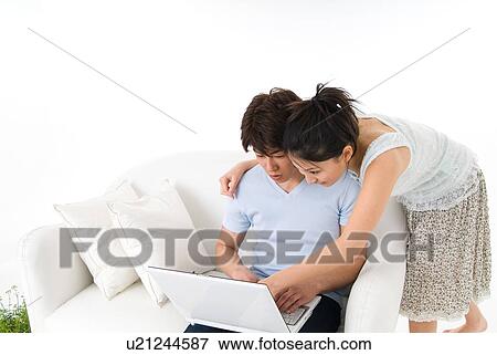 Young couple using laptop computer View Large Photo Image Stock Photo - Young couple using laptop computer. Fotosearch