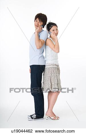 Young couple using mobile phone View Large Photo Image Stock Image - Young couple using mobile phone. Fotosearch
