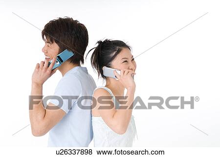 Young couple using mobile phone View Large Photo Image Stock Photo - Young couple using mobile phone. Fotosearch