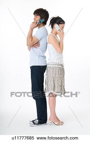 Stock Photography - Young couple using mobile phone. Fotosearch