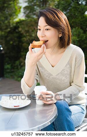 A mid adult woman eating toast View Large Photo Image Stock Photo - A mid adult woman eating toast. Fotosearch