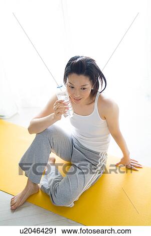 A mid adult woman holding a bottle of water View Large Photo Image Stock Image - A mid adult woman holding a bottle of water. Fotosearch