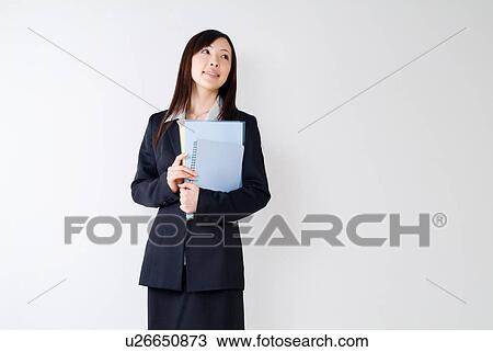 Stock Image - A mid adult woman holding documents. Fotosearch