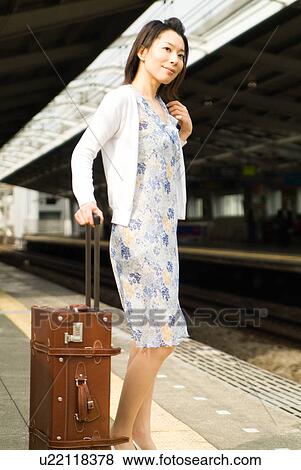 A mid adult woman standing with suitcase View Large Photo Image Stock Photo - A mid adult woman standing with suitcase. Fotosearch