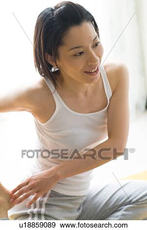 Stock Photo - A mid adult woman stretching. Fotosearch