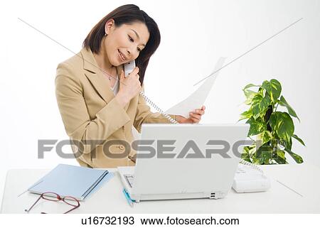 A mid adult woman talking over phone View Large Photo Image Stock Image - A mid adult woman talking over phone. Fotosearch