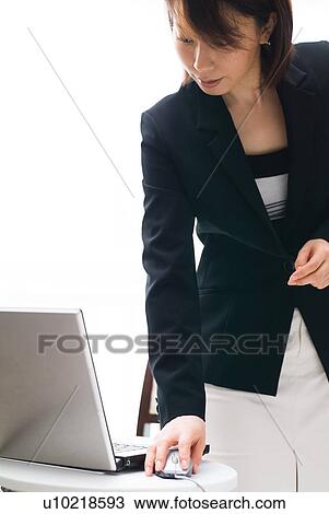 Stock Image - A mid adult woman using computer. Fotosearch