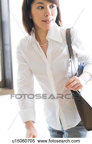 A mid adult woman walking with a bag View Large Photo Image Stock Photography - A mid adult woman walking with a bag. Fotosearch