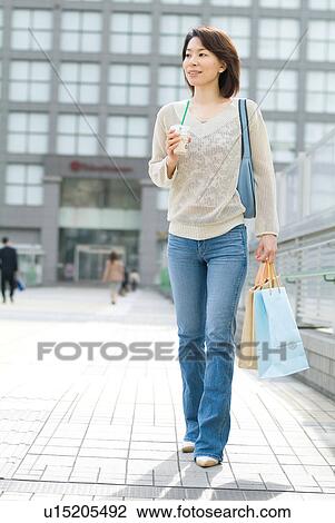 A mid adult woman walking with shopping bags View Large Photo Image Stock Image - A mid adult woman walking with shopping bags. Fotosearch