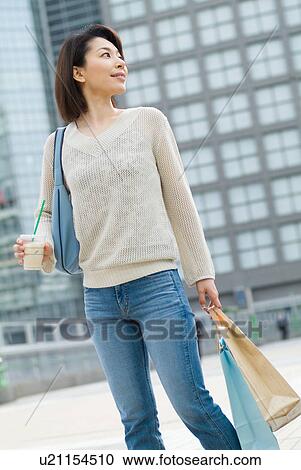 A mid adult woman walking with shopping bags View Large Photo Image Stock Image - A mid adult woman walking with shopping bags. Fotosearch