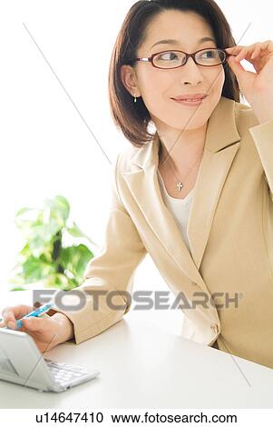 A mid adult woman with glasses looking away View Large Photo Image Stock Image - A mid adult woman with glasses looking away. Fotosearch