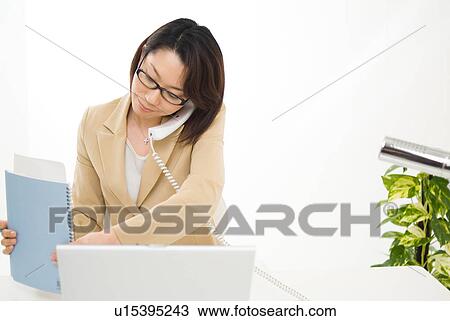Stock Image - A mid adult woman working. Fotosearch