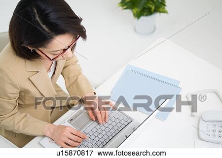 A mid adult woman working with computer View Large Photo Image Stock Photo - A mid adult woman working with computer. Fotosearch