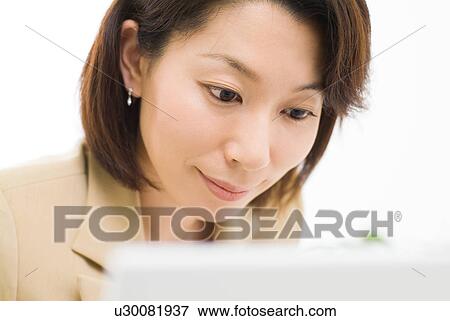 Stock Photo - A mid adult woman working with computer. Fotosearch
