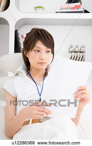 Stock Photo - A young woman reading document. Fotosearch